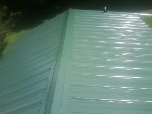 New green metal panels meeting at the ridge of a roof in Oakland